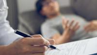 Doctor writing prescription for a patient.